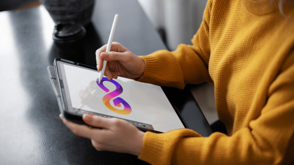 Female designer using a tablet to create a logo design in a modern workspace.
