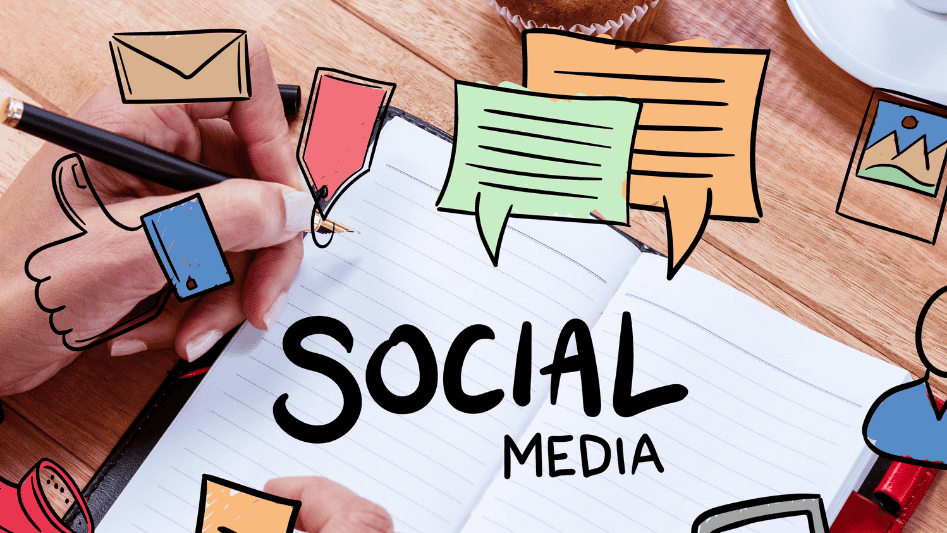 Hand writing 'SOCIAL MEDIA' on a notebook, surrounded by colorful icon stickers, symbolizing social media marketing.