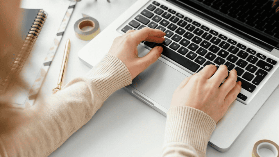 Person typing on a laptop, illustrating content writing.