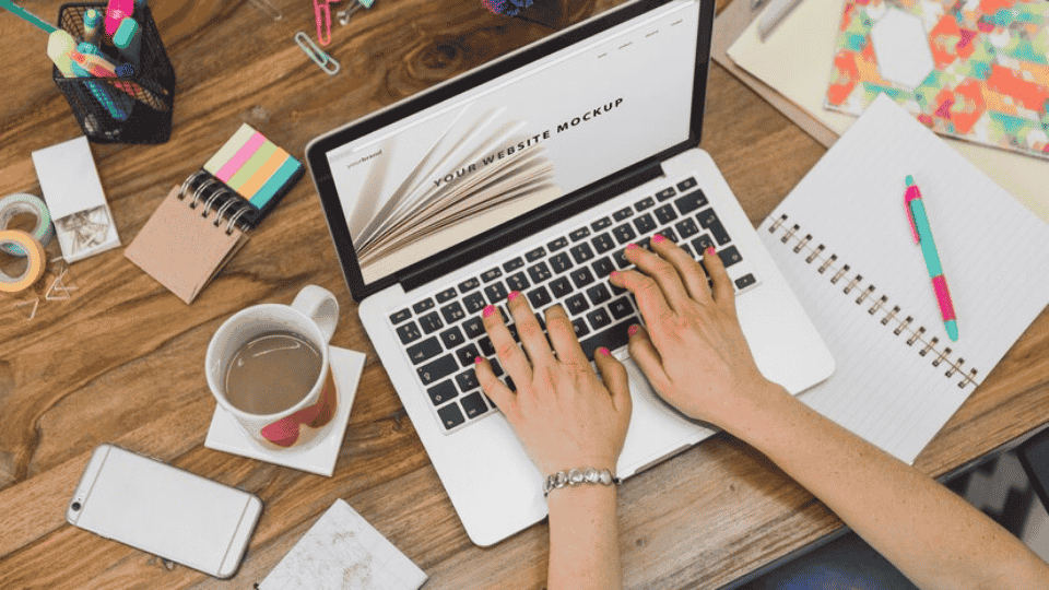 Designer working on a laptop, creating KL Company Profile Design.