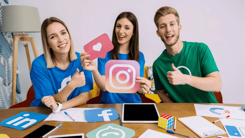 Team holding social media icons, emphasizing Social Media Marketing.